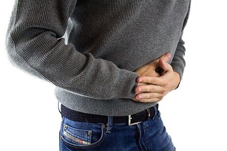 e Mann huet Symptomer vun der Gastritis